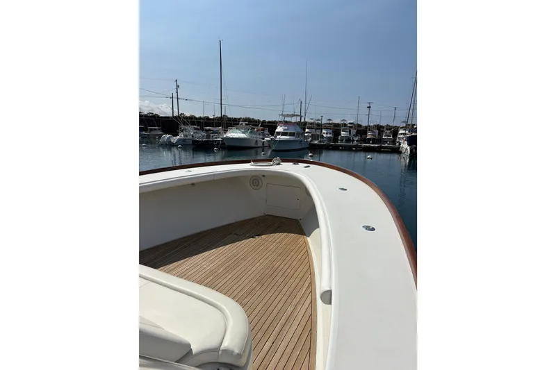 Slide: The Image of 2007 Gamefisherman 42 Walkaround boat interior with cushioned seating and wooden flooring. - 70