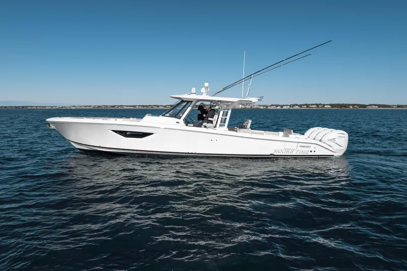 Slide: The Image of 2023 Pursuit S 428 Sport boat cruising on open water under clear blue sky. - 10