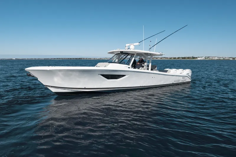 Slide: The Image of 2023 Pursuit S 428 Sport boat cruising on open water under clear blue sky. - 12