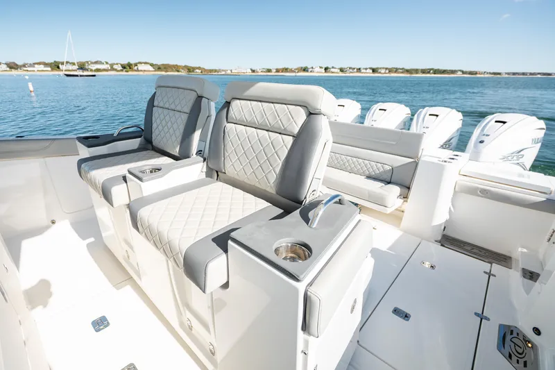 Slide: The Image of 2023 Pursuit S 428 Sport boat interior with luxurious seating and multiple outboard engines. - 19