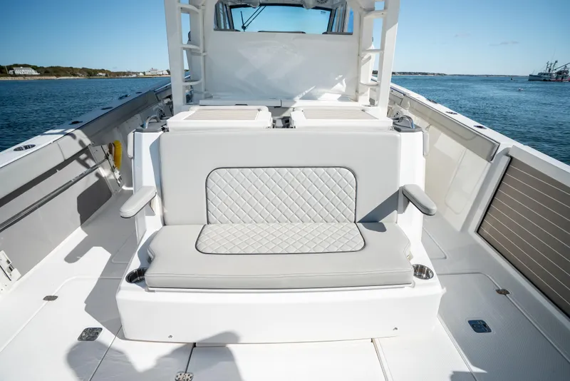Slide: The Image of 2023 Pursuit S 428 Sport boat interior with cushioned seating and ocean view. - 27