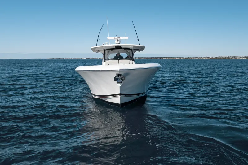 Slide: The Image of 2023 Pursuit S 428 Sport boat cruising on open water under clear blue sky. - 3