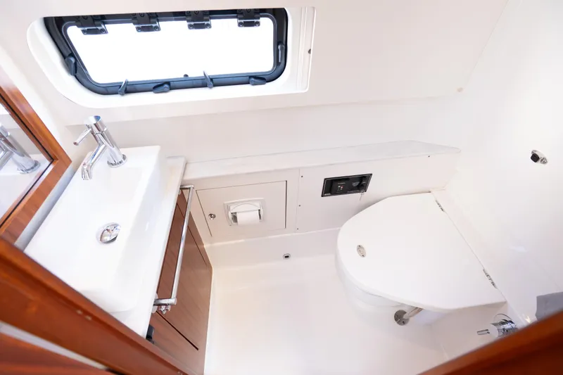 Slide: The Image of 2023 Pursuit S 428 Sport boat bathroom with sink, toilet, and window. - 32