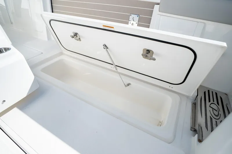 Slide: The Image of 2023 Pursuit S 428 Sport boat storage compartment open, showcasing interior space. - 33