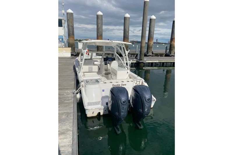 Slide: The Image of 2025 Sea Fox 268 Traveler boat docked with twin engines, under cloudy sky. - 3