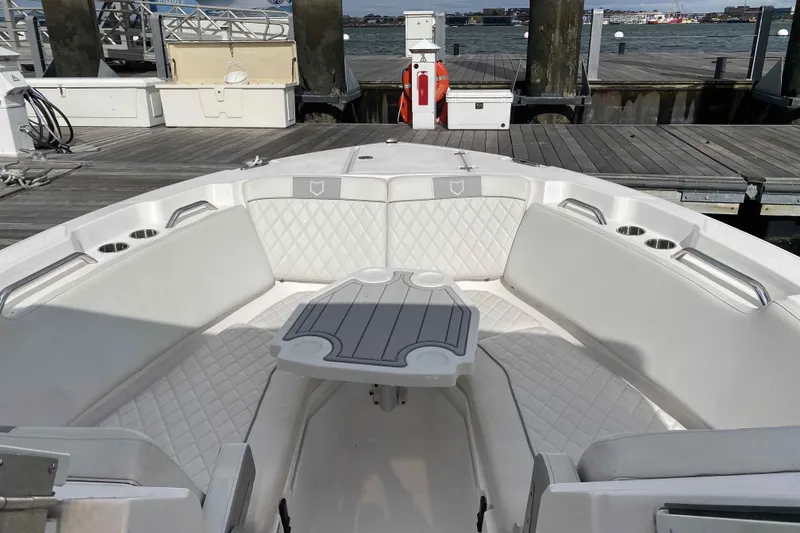 Slide: The Image of 2025 Sea Fox 268 Traveler boat interior with cushioned seating and table at dock. - 7