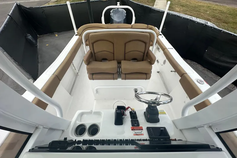 Slide: The Image of 2020 Sea Hunt Ultra 255 SE boat interior with brown seating and steering console. - 107