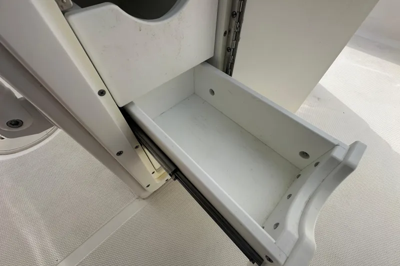 Slide: The Image of Storage compartment with plastic containers on a 2020 Sea Hunt Ultra 255 SE boat. - 116