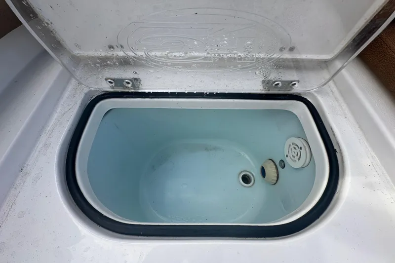 Slide: The Image of 2020 Sea Hunt Ultra 255 SE boat storage compartment with brown seating. - 131