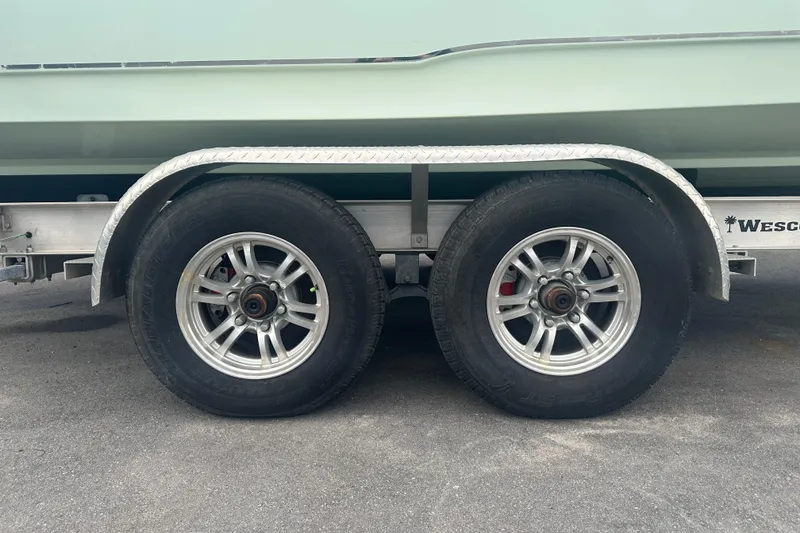 Slide: The Image of Trailer wheels of a 2020 Sea Hunt Ultra 255 SE boat on asphalt. - 2