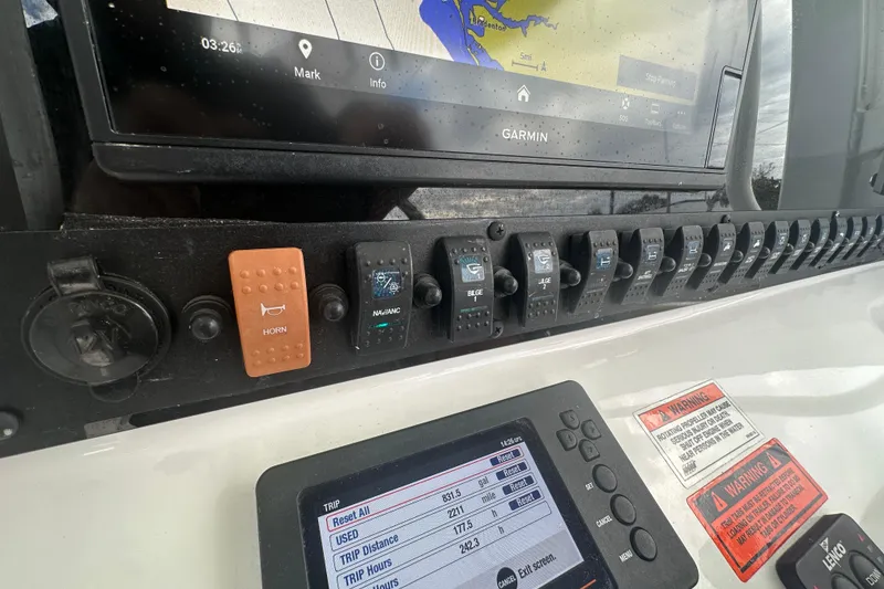 Slide: The Image of Control panel of a 2020 Sea Hunt Ultra 255 SE boat with various switches. - 50