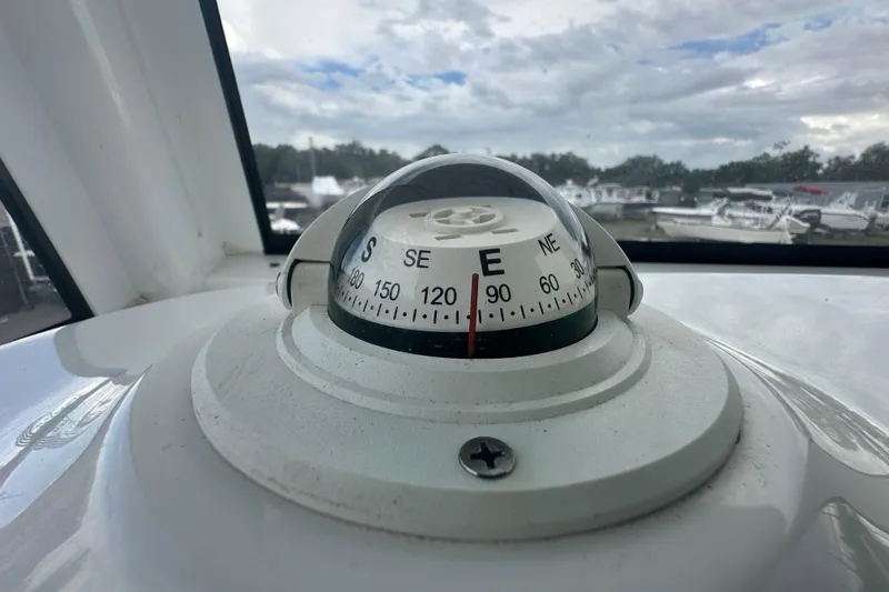 Slide: The Image of 2020 Sea Hunt Ultra 255 SE boat interior with seating and console, docked under cloudy skies. - 64