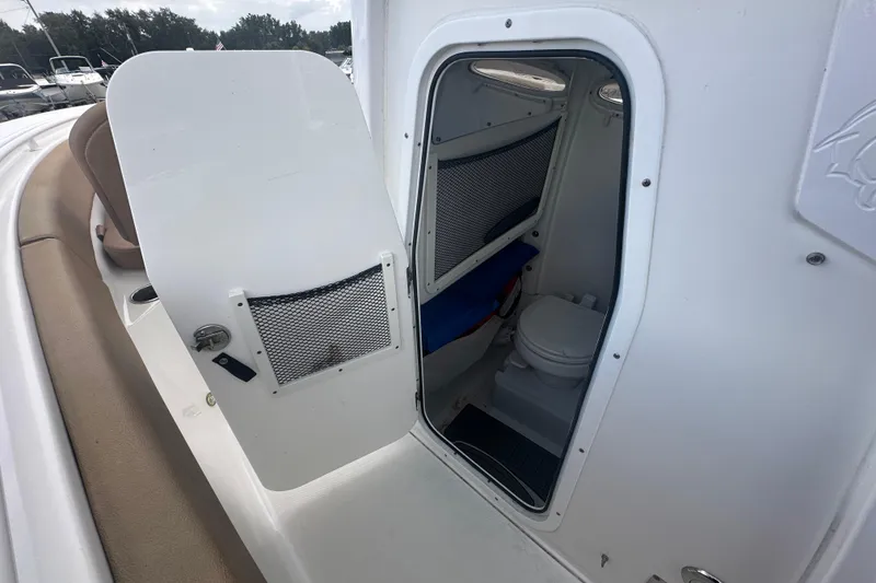 Slide: The Image of 2020 Sea Hunt Ultra 255 SE boat interior with toilet and storage area. - 67
