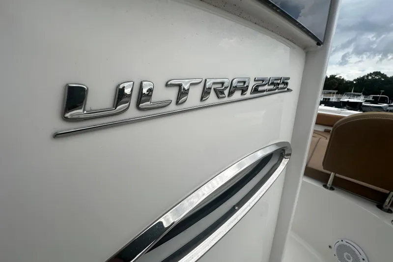 Slide: The Image of 2020 Sea Hunt Ultra 255 SE boat interior with tan seating and cup holders. - 73