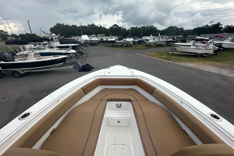 Slide: The Image of 2020 Sea Hunt Ultra 255 SE boat with tan cushioned seating in the bow area. - 76