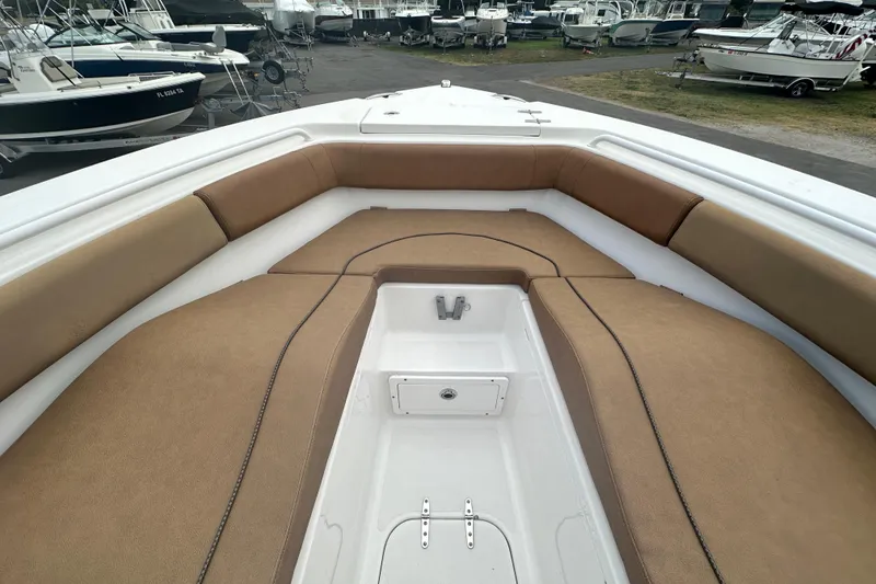 Slide: The Image of 2020 Sea Hunt Ultra 255 SE boat interior with tan seating and storage compartment. - 78