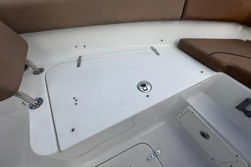 Slide: The Image of 2020 Sea Hunt Ultra 255 SE boat with tan cushioned seating in a marina setting. - 81