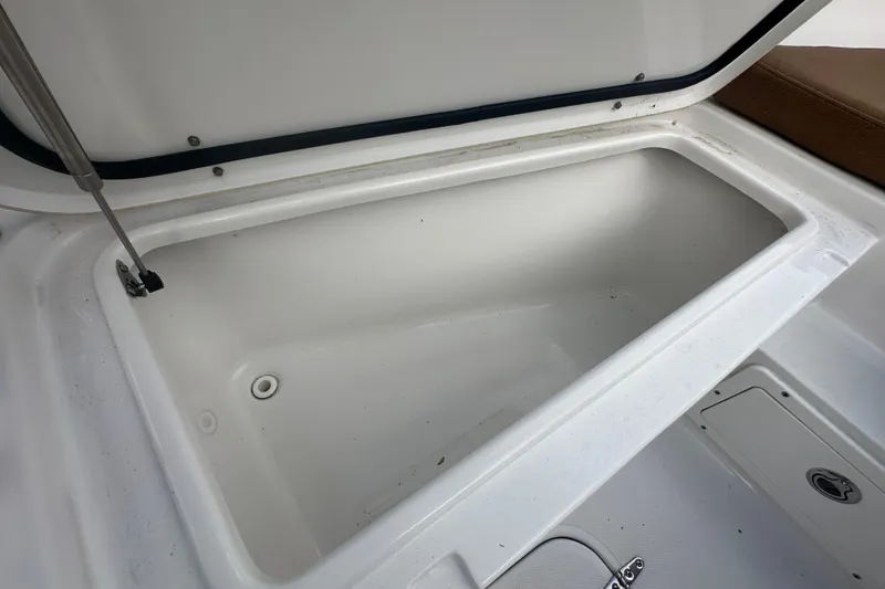 Slide: The Image of 2020 Sea Hunt Ultra 255 SE boat interior with brown seating and storage compartments. - 82