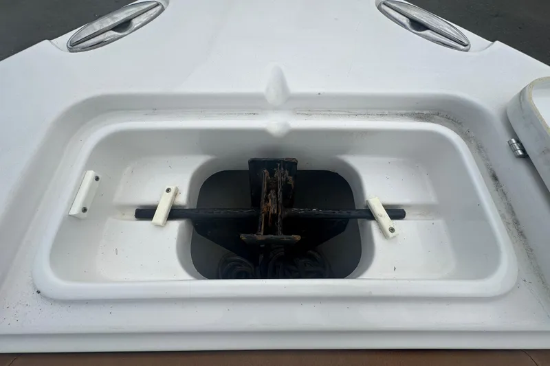 Slide: The Image of 2020 Sea Hunt Ultra 255 SE boat with tan seating, displayed outdoors near a road. - 94