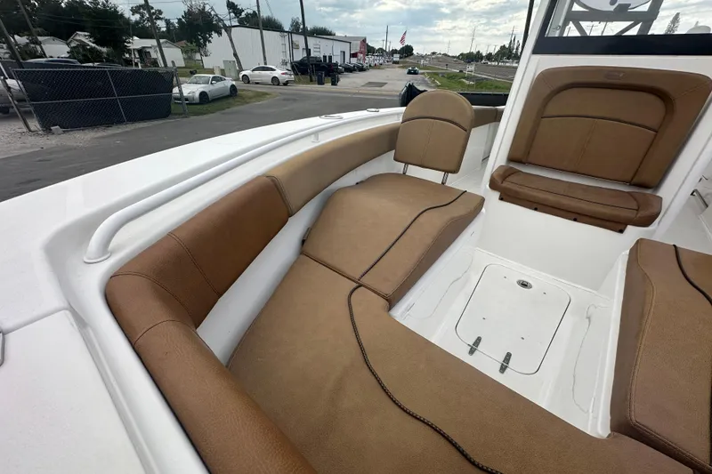 Slide: The Image of 2020 Sea Hunt Ultra 255 SE boat interior with brown cushioned seating. - 98