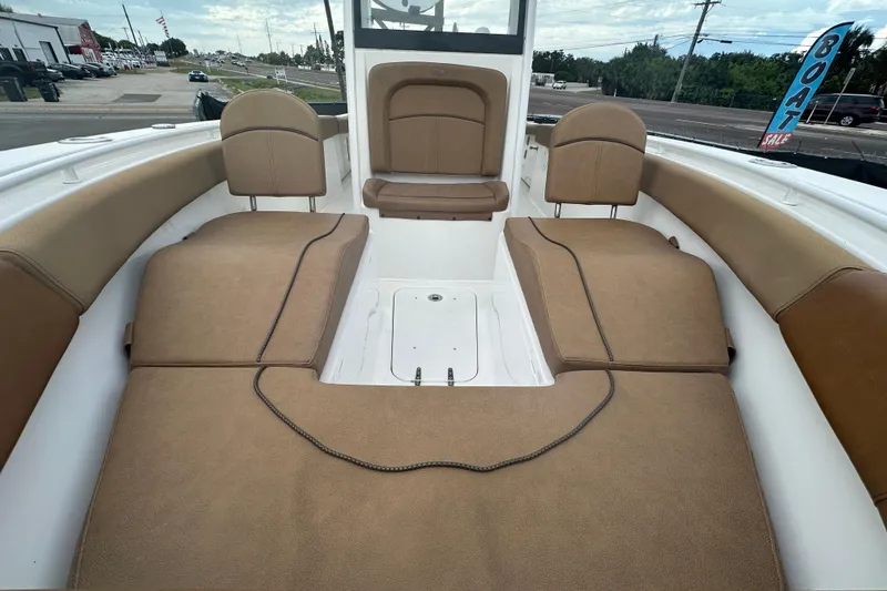 Slide: The Image of 2020 Sea Hunt Ultra 255 SE boat at dealership, cloudy sky, "Boat Sale" sign visible. - 99