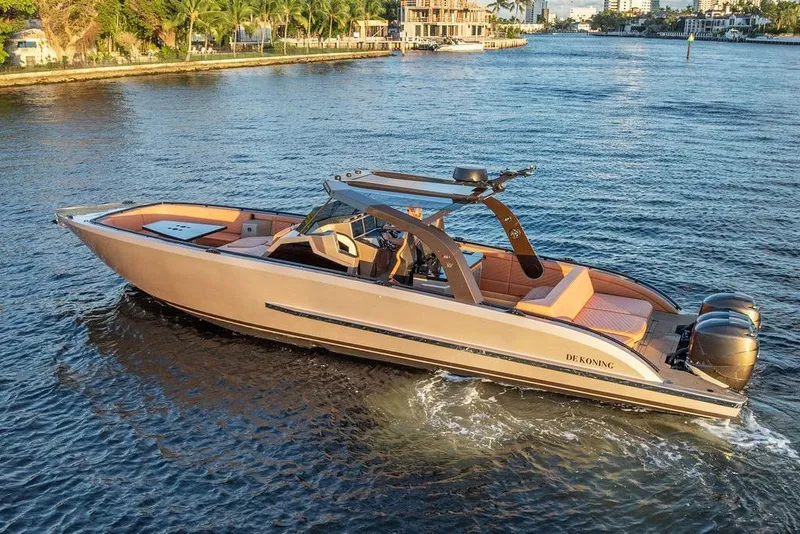 Slide: The Image of 2023 DeKoning 43 boat cruising on a scenic waterway. - 2