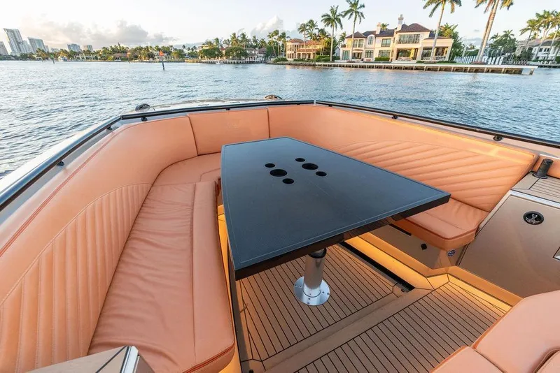 Slide: The Image of Luxurious 2023 DeKoning 43 yacht interior with elegant seating and table, overlooking waterfront homes. - 23