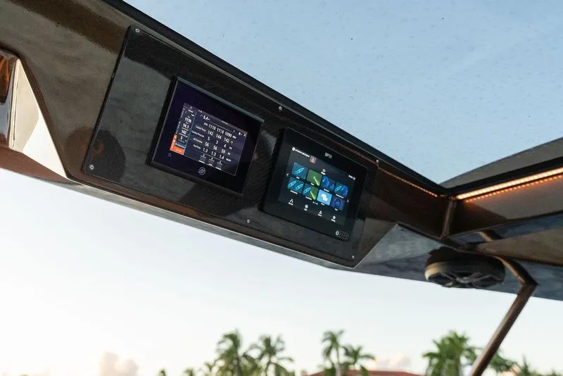 Slide: The Image of Control panel of 2023 DeKoning 43 boat with digital displays and scenic background. - 24