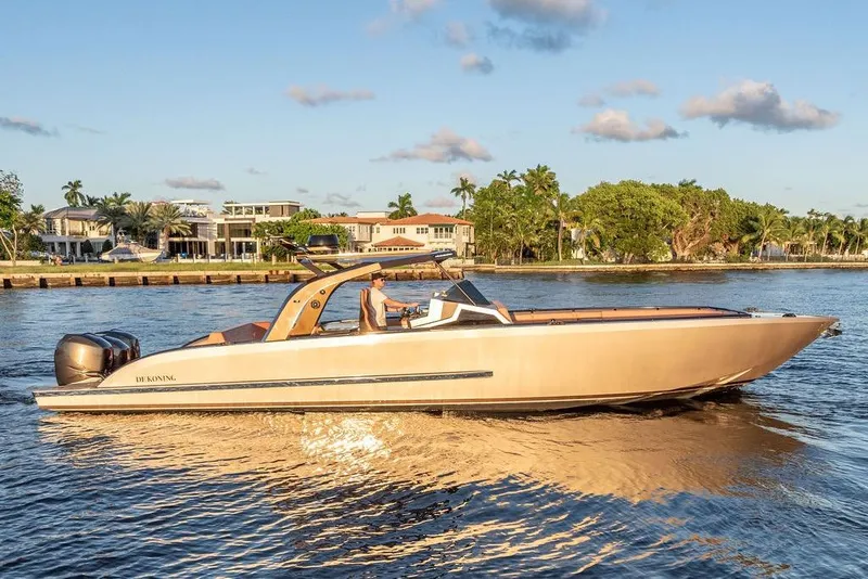 Slide: The Image of 2023 DeKoning 43 luxury boat cruising on a sunny waterfront. - 5