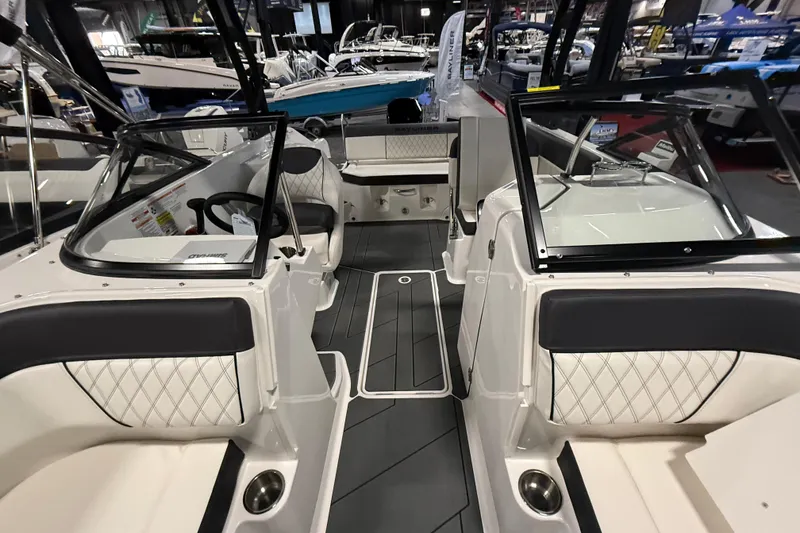 Slide: The Image of 2026 Bayliner D22 boat interior with modern seating and sleek design at a boat show. - 2