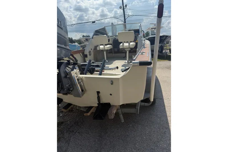Slide: The Image of 1980 Boston Whaler Revenge 20 boat, rear view with outboard motor, parked outdoors. - 4