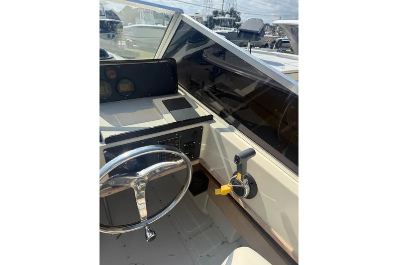 Slide: The Image of 1980 Boston Whaler Revenge 20 boat cockpit with steering wheel and control panel. - 6