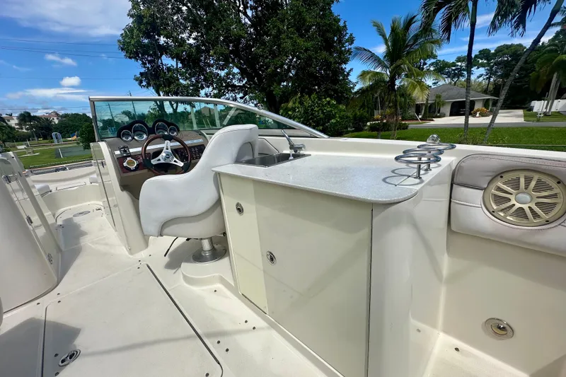 Slide: The Image of 2010 Sea Ray 280 Sundeck interior with helm, seating, and outdoor amenities under clear skies. - 17