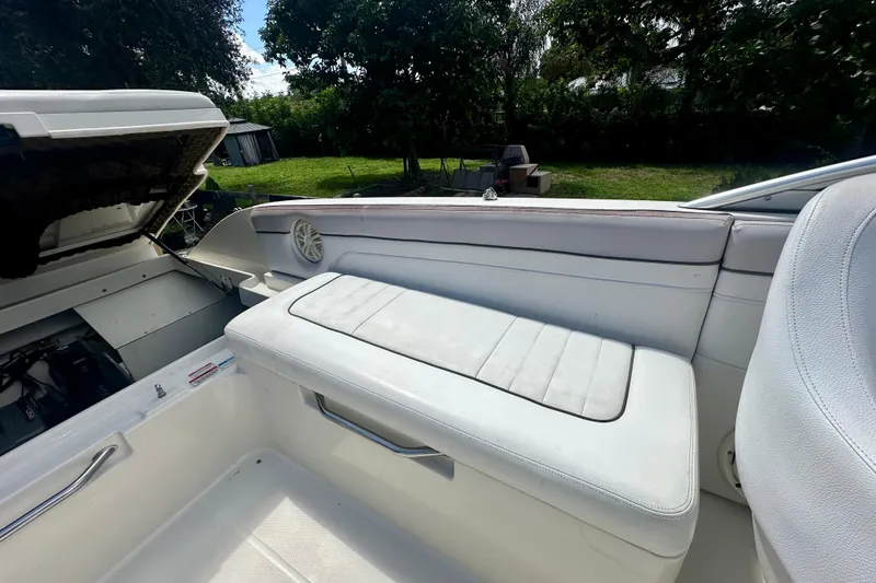 Slide: The Image of 2010 Sea Ray 280 Sundeck interior with white seating and open engine compartment. - 19