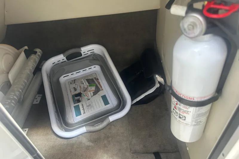 Slide: The Image of Storage area in a 2010 Sea Ray 280 Sundeck with fire extinguisher and basket. - 29