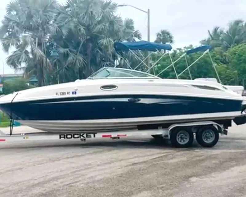 Slide: The Image of 2010 Sea Ray 280 Sundeck boat on trailer, parked near palm trees. - 3