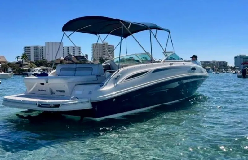 Slide: The Image of 2010 Sea Ray 280 Sundeck boat on clear water with cityscape background. - 4