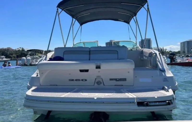 Slide: The Image of 2010 Sea Ray 280 Sundeck boat on water, rear view with canopy, sunny day. - 5