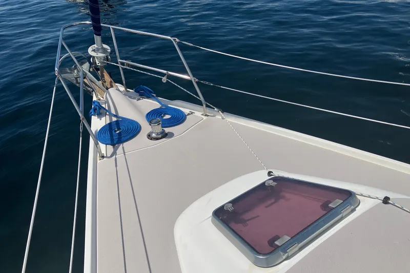 Slide: The Image of Bow of 2008 Catalina 350 MkII sailboat with ropes and hatch on calm water. - 14