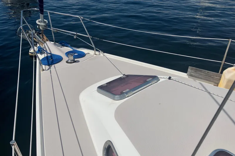 Slide: The Image of 2008 Catalina 350 MkII sailboat deck with hatch and railing on calm water. - 20