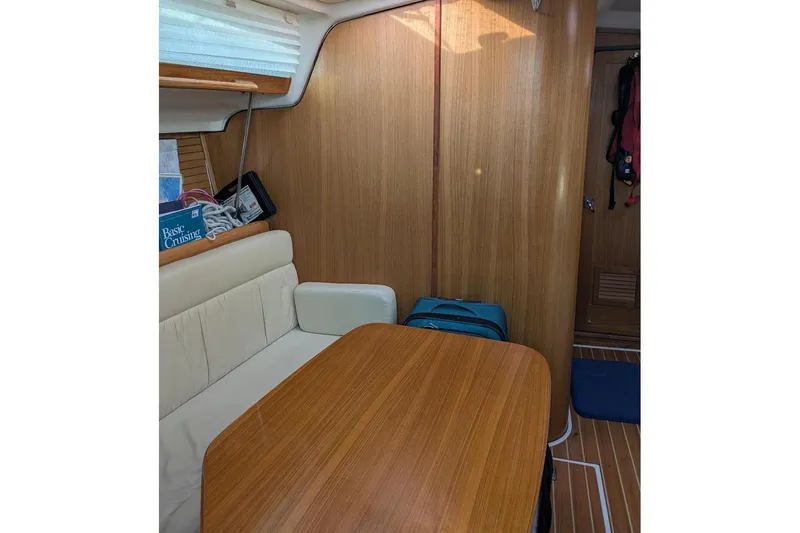 Slide: The Image of 2008 Catalina 350 MkII interior with wooden table, cushioned seating, and nautical decor. - 9