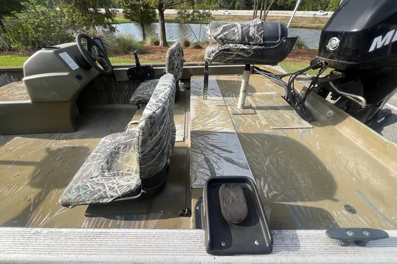 Slide: The Image of 2012 Tracker Grizzly 1754 SC boat interior with camo seats and Mercury outboard motor. - 7