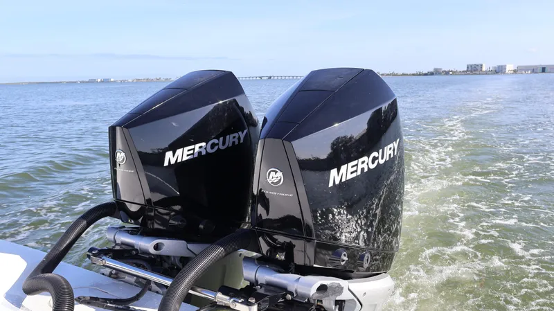 Slide: The Image of Twin Mercury outboard engines on a 2022 Yellowfin 32 Offshore boat cruising on open water. - 13