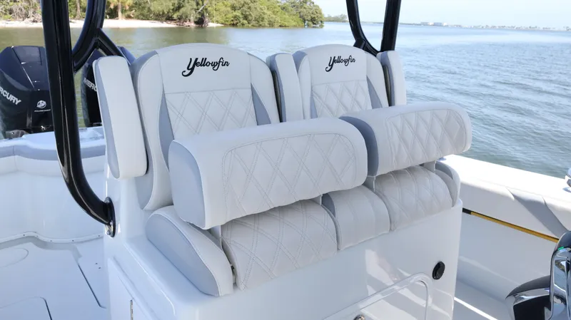 Slide: The Image of 2022 Yellowfin 32 Offshore boat seats with diamond stitching, near water. - 22