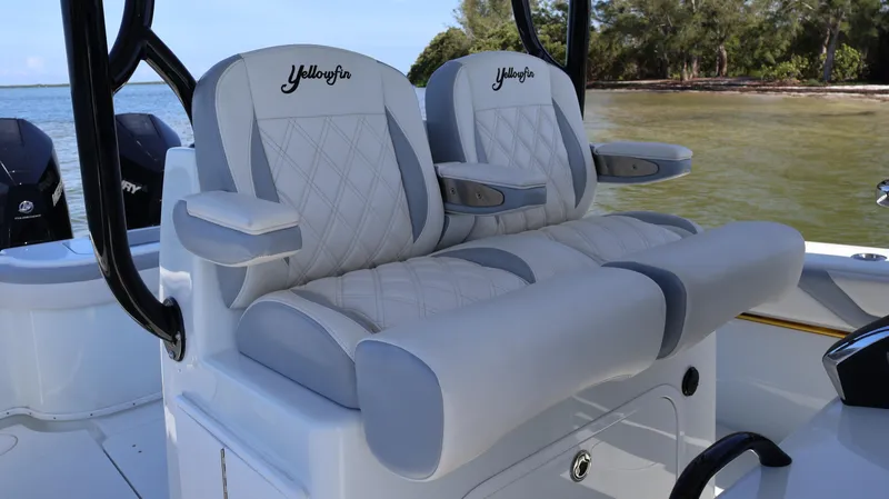 Slide: The Image of 2022 Yellowfin 32 Offshore boat seats with diamond stitching, set against a scenic water backdrop. - 23