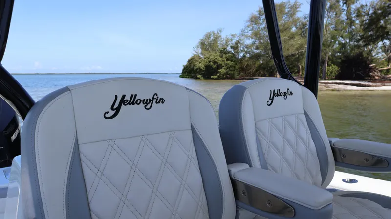 Slide: The Image of 2022 Yellowfin 32 Offshore boat seats with embroidered logo, near scenic shoreline. - 24