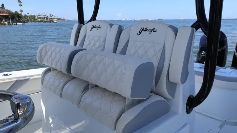 Slide: The Image of 2022 Yellowfin 32 Offshore boat seats with diamond stitching, overlooking a serene water view. - 25