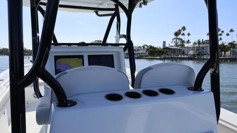 Slide: The Image of 2022 Yellowfin 32 Offshore boat console with navigation screens, on a sunny day near the shore. - 29