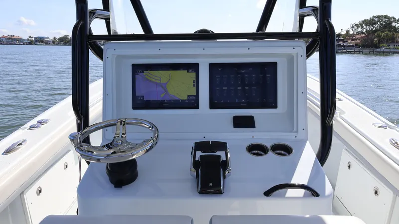 Slide: The Image of 2022 Yellowfin 32 Offshore boat dashboard with navigation screens and steering wheel. - 31