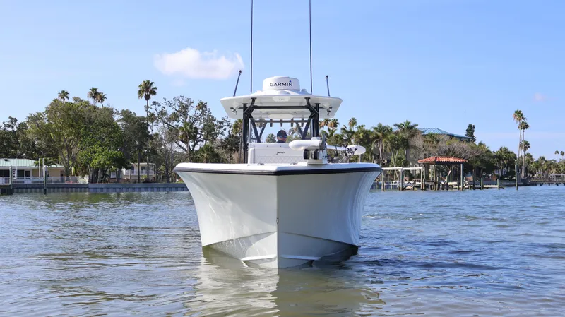 Slide: The Image of 2022 Yellowfin 32 Offshore boat on calm water, surrounded by palm trees. - 6